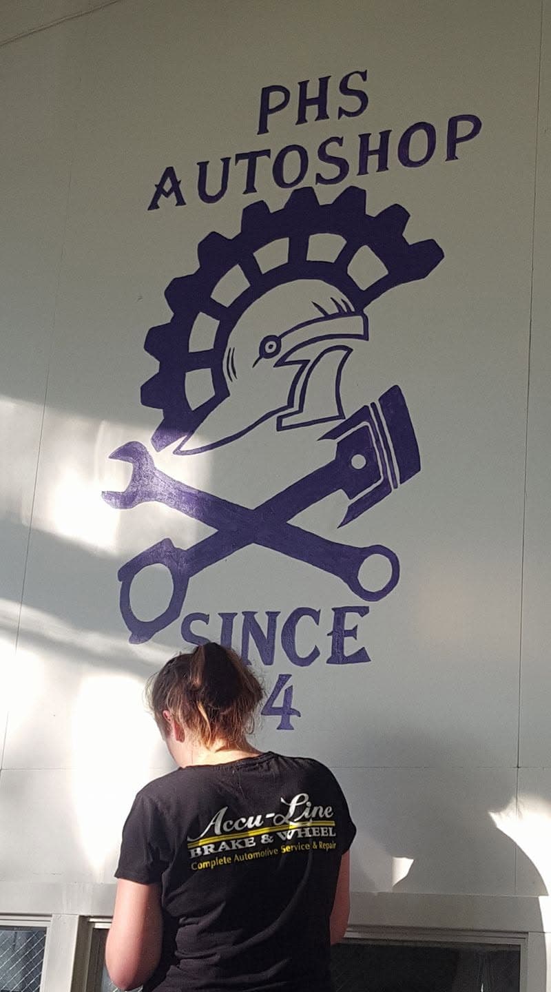 Tara at the Petaluma High School Auto Shop mural, wearing an Accu-Line Brake & Wheel shirt